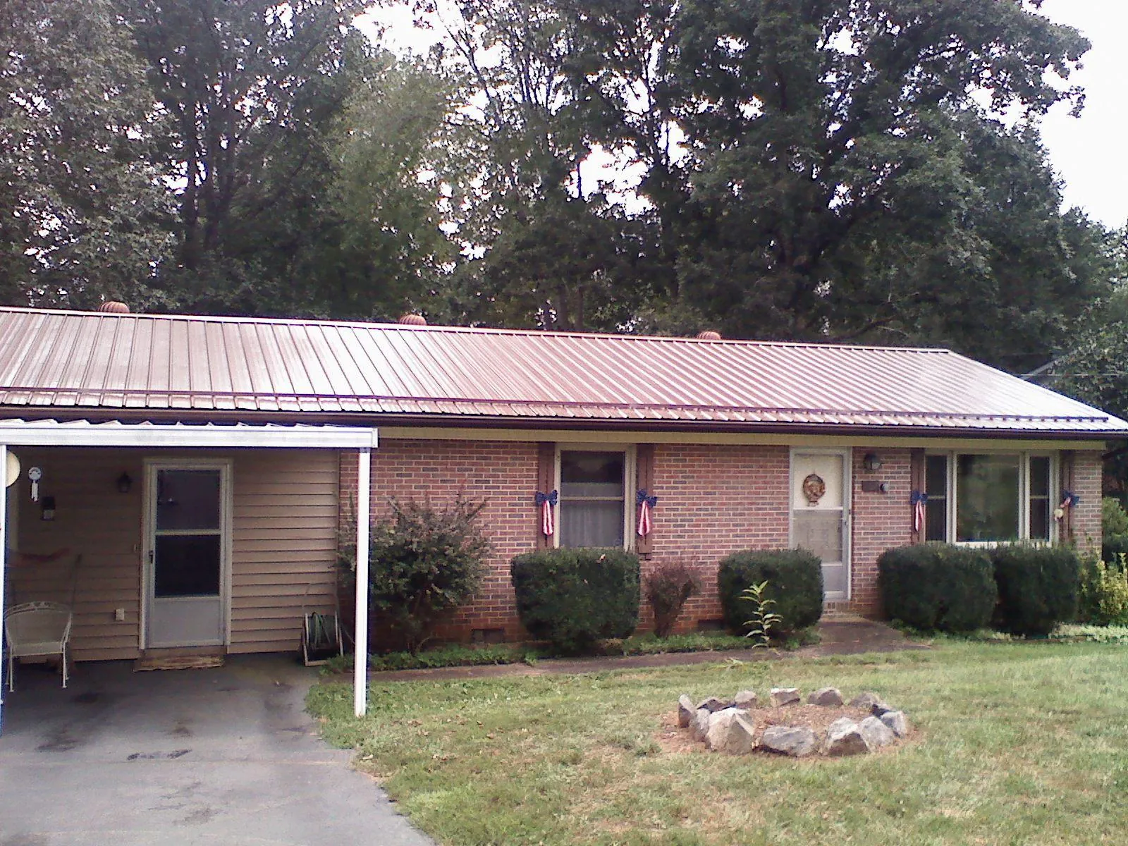 Bronze metal roof and carport on a brick ranch home — Roof Repair work by our crew in Elkridge